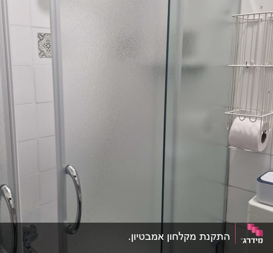 אמבטיון זכוכית מחוספסת המותקן על אמבטיה בחדר רחצה